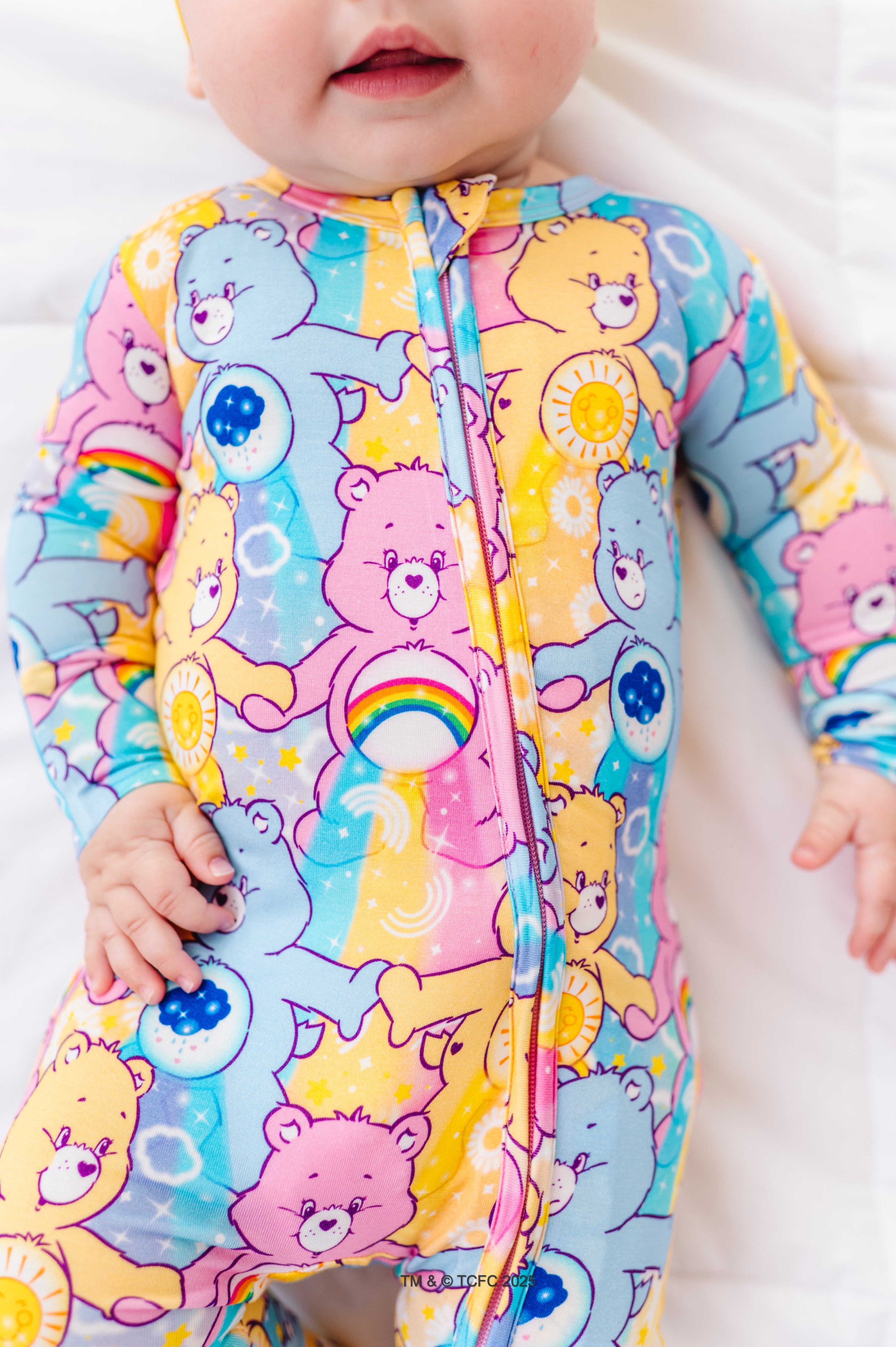 Close-up of Care Bears™ Stare bamboo romper showing vibrant Care Bears characters and rainbow belly badges